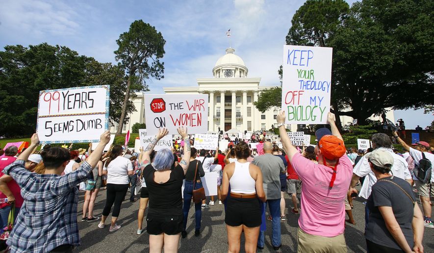FILE - In this Sunday, May 19, 2019, file photo, protesters for women's rights hold a rally on the Alabama Capitol steps to protest a law passed the previous week making abortion a felony in nearly all cases with no exceptions for cases of rape or incest, in Montgomery, Ala. An Alabama-based abortion rights group used a flood of donations that poured in from across the country after the abortion ban to purchase the state’s busiest abortion clinic to ensure it stays open, the Yellowhammer Fund announced Friday, May 15, 2020. (AP Photo/Butch Dill, File)