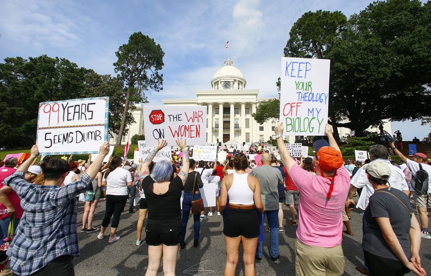 FILE - In this Sunday, May 19, 2019, file photo, protesters for women's rights hold a rally on the Alabama Capitol steps to protest a law passed the previous week making abortion a felony in nearly all cases with no exceptions for cases of rape or incest, in Montgomery, Ala. An Alabama-based abortion rights group used a flood of donations that poured in from across the country after the abortion ban to purchase the state’s busiest abortion clinic to ensure it stays open, the Yellowhammer Fund announced Friday, May 15, 2020. (AP Photo/Butch Dill, File)