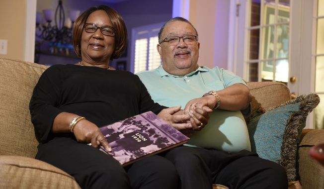 In this Friday, May 1, 2020 photo, Patricia and Terry Elam pose at their home in Augusta, Ga. The couple were students at Paine College during the 1970 riot in Augusta when they had to flee the college during the unrest 50 years ago. (Michael Holahan/The Augusta Chronicle via AP)