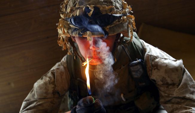 Lcpl. Charles Williams from Lafayette, Indiana, from the 1st Battalion 5th Marines lights a cigarette while searching buildings in Fallujah, Iraq Monday, April 19, 2004.  (AP Photo /John Moore) ** FILE **