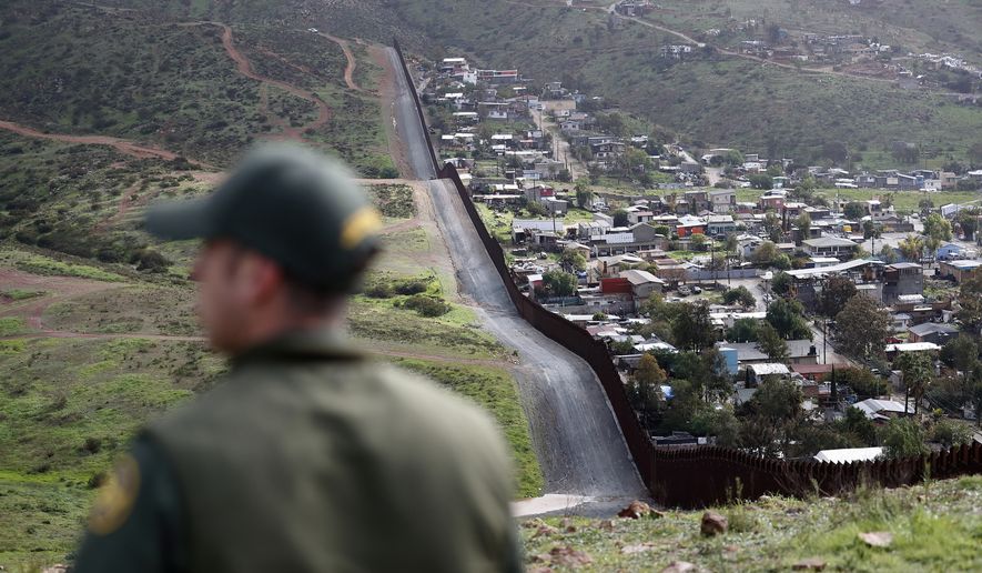 In this Feb. 5, 2019, file photo, Border Patrol agent Vincent Pirro looks on near a border wall that separates the cities of Tijuana, Mexico, and San Diego, in San Diego. (AP Photo/Gregory Bull) **FILE**