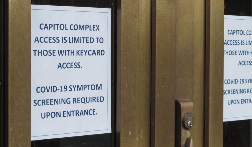 A sign is posted on the front doors of the Alaska Capitol on Monday, May 18, 2020, in Juneau, Alaska. The Alaska Legislature planned to reconvene Monday to address use of federal coronavirus relief funds, with protocols in place aimed at guarding against the virus. (AP Photo/Becky Bohrer)