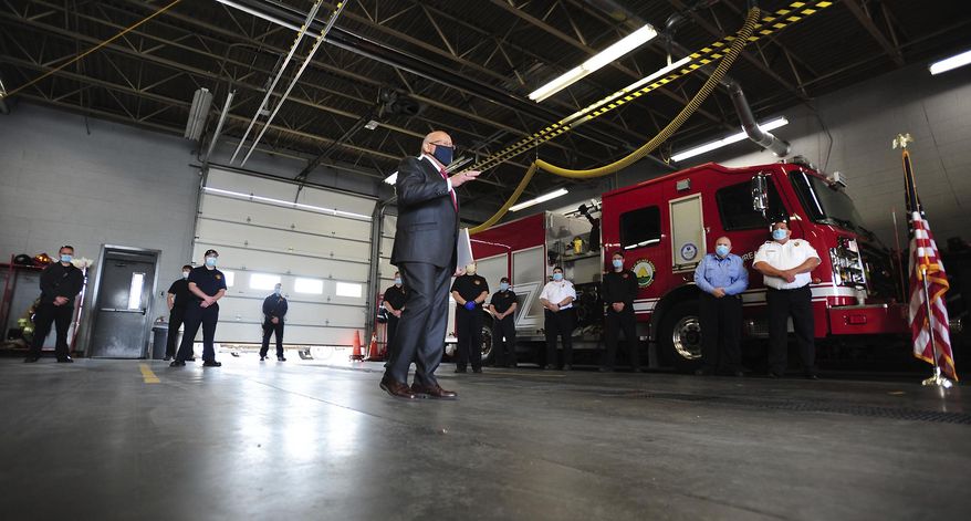 Wilkes-Barrre City Mayor George C. Brown, center, offers remarks before presenting a proclamation to the Wilkes-Barre Fire City Department and Emergency Medical Service responders, Monday, May 18, 2020 at Fire Department headquarters in Wilkes-Barre, Pa. The proclamation recognizes Emergency Medical Services Week which is May 17-23. (Mark Moran/The Citizens' Voice via AP)