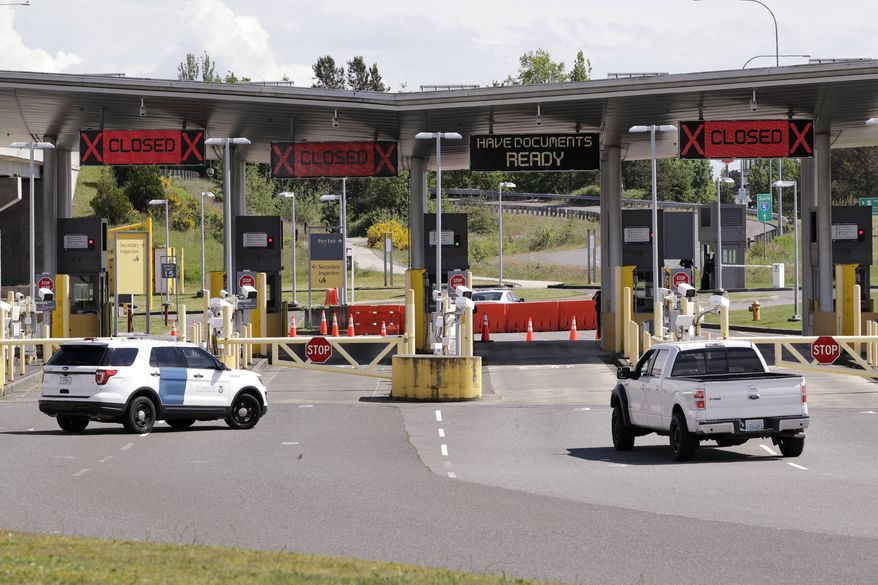 In this photo taken Sunday, May 17, 2020, a truck from Canada heads to the single open lane heading into the U.S. at the Peace Arch border crossing in Blaine, Washington. (AP Photo/Elaine Thompson) **FILE**