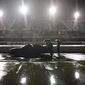 A crew pushes a car through the pit area at Darlington Raceway after the NASCAR Xfinity series auto race was postponed because of rain Tuesday, May 19, 2020, in Darlington, S.C. (AP Photo/Brynn Anderson)