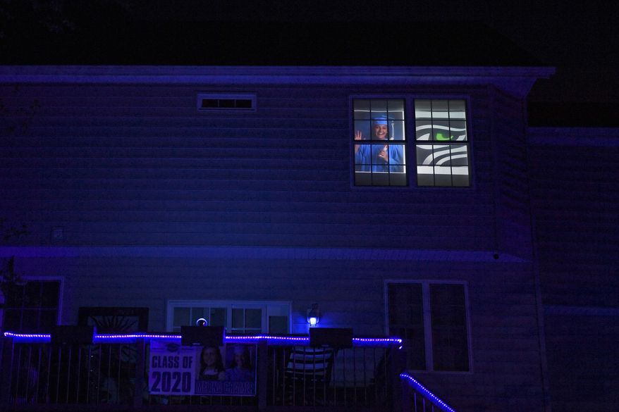 A photo of South River High School Class of 2020 senior Melina Cramer is displayed in the window of her home in Edgewater, Md., Tuesday, April 21, 2020. Many of the South River High School families found ways to celebrate their seniors. Cramer's mother, Mary Cramer, felt she needed to be as creative as possible this year to make sure her daughter felt special given that the traditional senior activities were canceled because of the coronavirus pandemic. (AP Photo/Susan Walsh)