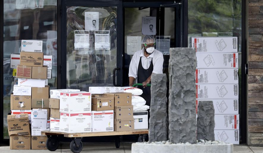 A worker pushes a cart of supplies into Greenbrier Health Center, Tuesday, May 19, 2020, in Parma Heights, Ohio. The number of deaths from the coronavirus in Ohio's nursing homes is now over 1,000. That means long-term centers account for three out of five deaths from the virus in the state. Greenbrier has at least 24 cumulative resident cases and 12 cumulative staff cases. (AP Photo/Tony Dejak)