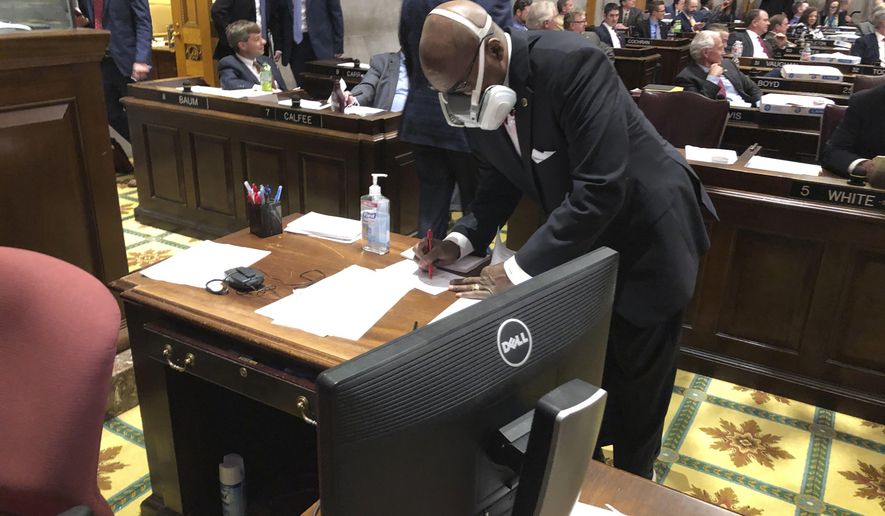 FILE - In this March 19, 2020 file photo State Rep. G.A. Hardaway, D-Memphis, wears a mask during House floor proceedings in Nashville, Tenn., amid the coronavirus pandemic. Sharing information about people who have tested positive or been exposed to COVID-19 with first responders does not violate medical privacy laws, under guidance issued by the U.S. Department of Health and Human Services. That has not quelled skepticism about how the data is used. “Tell us how it’s working for you, then tell us how well it’s been working; don’t just tell us you need it for your job,” said Hardway, a Memphis Democrat who chairs the Tennessee Black Caucus. (AP Photo/Jonathan Mattise, file)