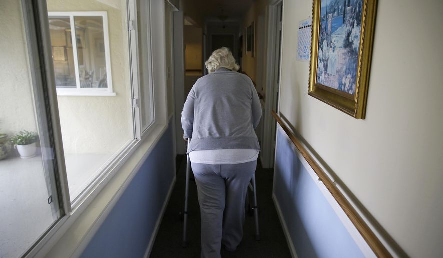 In this Dec. 5, 2019, file photo, a woman walks to her room at a senior care home in Calistoga, Calif. (AP Photo/Eric Risberg, File)