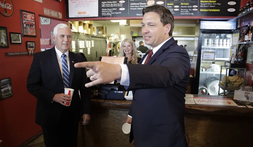 Vice President Mike Pence, left, and Florida gov. Ron DeSantis eat lunch at Beth&#39;s Burger Bar Wednesday, May 20, 2020, in Orlando, Fla. Pence is also scheduled to participate in a roundtable discussion with hospitality and tourism industry leaders to discuss their plans for re-opening(AP Photo/Chris O&#39;Meara)