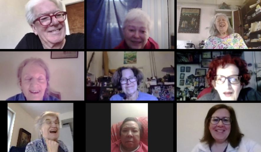 In this May 11, 2020, image made from video provided by Greenwich House, people laugh as they gather online for a comedy class through Greenwich House in New York. Professional comedian Jo Firestone leads the group through monologue bits and rapid-fire prompts as they all try for an hour to find humor during the coronavirus pandemic. (Courtesy of Celeste Kaufman/Greenwich House via AP)
