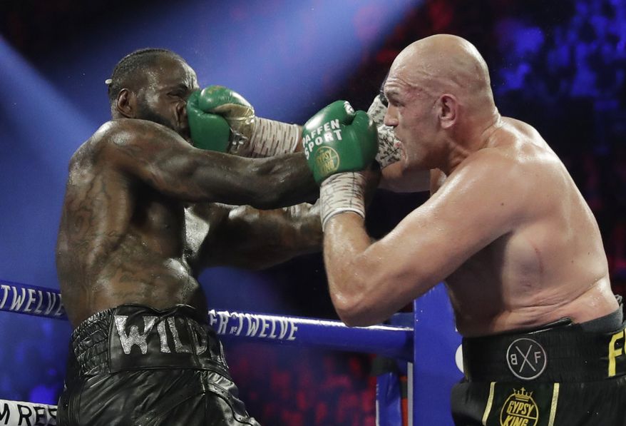 In this Feb. 22, 2020, file photo, Tyson Fury, of England, lands a right to Deontay Wilder, left, during a WBC heavyweight championship boxing match in Las Vegas. Boxing promoter Bob Arum says he plans to stage a card of five fights on June 9 at the MGM Grand. It's the first of a series of fights over the next two months at the Las Vegas hotel. A second fight card will be held two nights later. ESPN will televise both cards to kick off twice weekly shows at the hotel in June and July. The fights are pending approval of the Nevada Athletic Commission. (AP Photo/Isaac Brekken, File) **FILE**