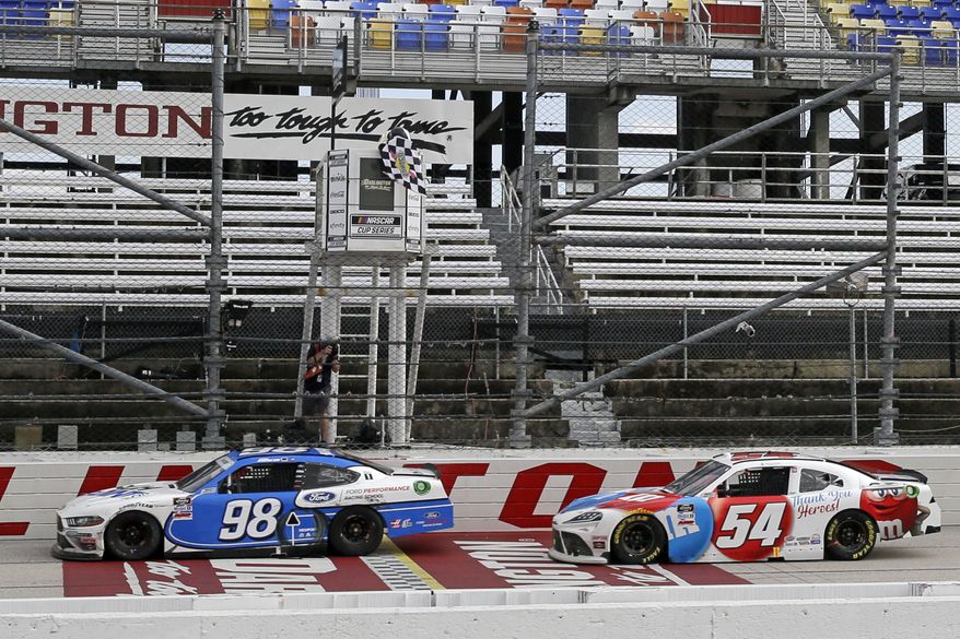 Chase Briscoe (98) crosses the finish line ahead of Kyle Busch (54) to win the NASCAR Xfinity series auto race Thursday, May 21, 2020, in Darlington, S.C. (AP Photo/Brynn Anderson)
