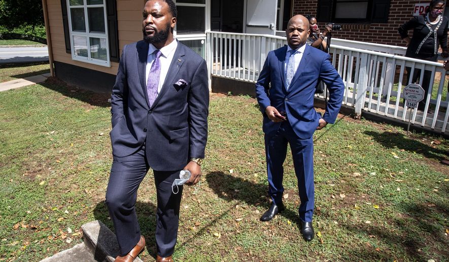 Lee Merritt, left, and Chris Stewart, attorneys for the mother of Ahmaud Arbery, are seen at a news conference on Wednesday, May 19, 2020, in East Point, Georgia. The attorneys appeared and spoke at a news conference held by the Atlanta branch of the NAACP. After a video of the shooting of Arbery emerged on social media, the Georgia Bureau of Investigation, arrested Gregory McMichael, 64, and his son, Travis McMichael, 34, and they were jailed on murder and aggravated assault charges. (AP Photo/Ron Harris)