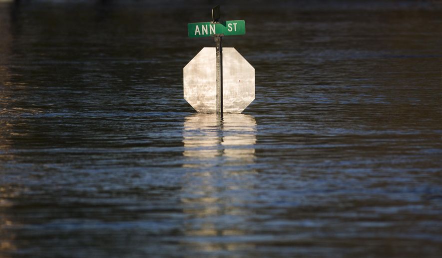 Floodwater reaches the bottom of a stop sign, Wednesday, May 20, 2020, in Midland, Mich. (Katy Kildee/Midland Daily News via AP)