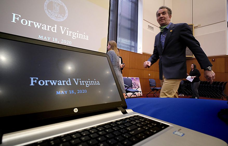 Virginia Governor Ralph Northam walks by a laptop projector as he leaves the room following the COVID-19 press briefing inside the Patrick Henry Building in Richmond, Va., Monday, May 18, 2020. (Bob Brown/Richmond Times-Dispatch via AP)