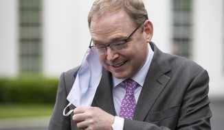 White House senior adviser Kevin Hassett removes his mask to speak with reporters at the White House, Friday, May 22, 2020, in Washington. (AP Photo/Alex Brandon)