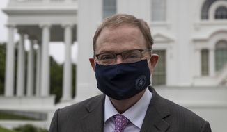 White House senior adviser Kevin Hassett walks with a mask on to speak with reporters at the White House, Friday, May 22, 2020, in Washington. (AP Photo/Alex Brandon)