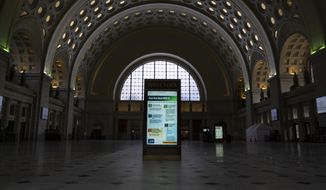 CDC information on how prevent the spread of germs and help prevent the spread of COVID-19 is illumination in the directory kiosk at a quiet Union Station in Washington, Thursday, May 22, 2020. (AP Photo/Carolyn Kaster)