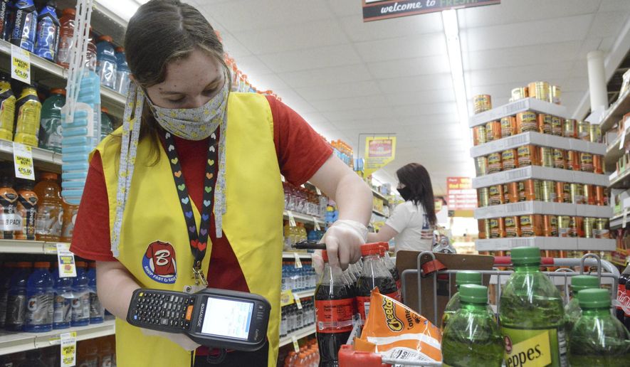 Skyla Yazujian, Boyer&#x27;s Food Markets employee, wearing a mask and gloves, scans items as she shops for a pickup order at Boyer&#x27;s in Orwigsburg, Pa., on Thursday, May 21, 2020. At Boyer&#x27;s, customers placing a pickup order can choose if they would like substitutes for out of stock items. (Lindsey Shuey/The Republican-Herald via AP)