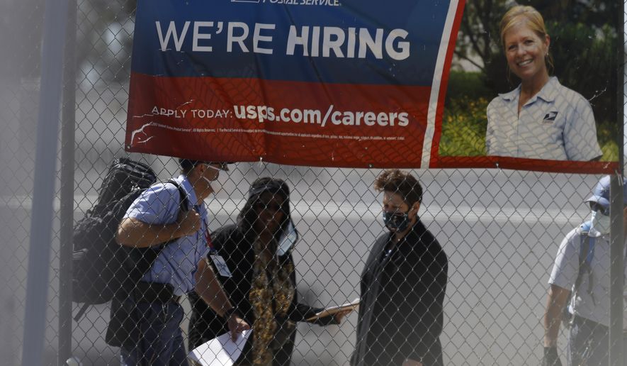 Employees meet outside the U.S. Postal Service distribution facility Friday, May 22, 2020, in east Denver. The facility, which handles 10-million pieces of mail daily for Colorado and Wyoming, is still open despite being ordered to shut down by city health officials because of a coronavirus outbreak investigation. (AP Photo/David Zalubowski)