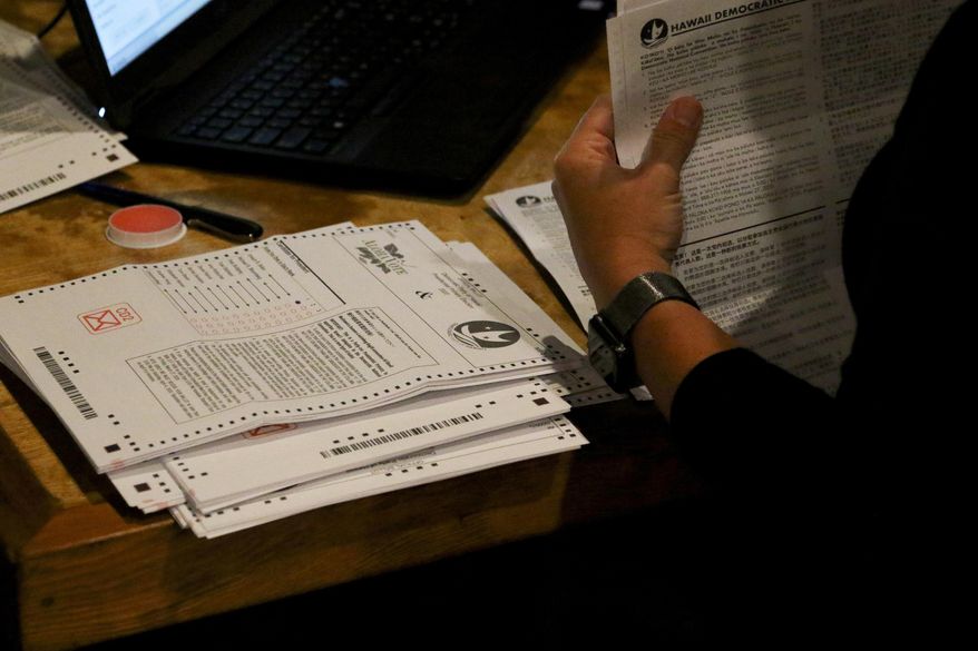 Democratic Party of Hawaii staff tabulate presidential primary ballots in Honolulu on Friday, May 22, 2020. The Democratic Party of Hawaii is scheduled Saturday to release the results of its party-run presidential primary which was delayed by more than a month due the coronavirus pandemic. The party expected most members to vote by mail and some to cast ballots at about 20 in-person polling sites. But concerns about the virus forced the party to cancel in-person voting and allow only mail ballots. (AP Photo/Caleb Jones)