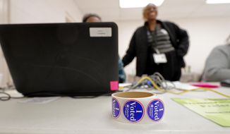 A roll of voting stickers sits on a table as people arrive to vote in the Democratic primary in Hopkins, S.C., Saturday, Feb. 29, 2020. (AP Photo/Gerald Herbert)