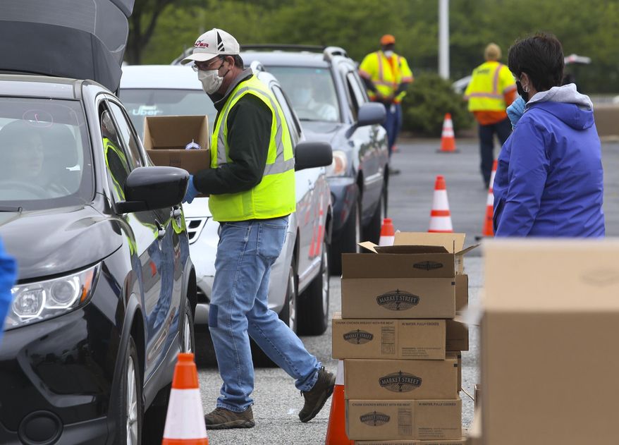 In this Wednesday May 20, 2020 photo, Food Bank of Delaware, DelDOT, the Delaware Army National Guard and scores of volunteers come together to serve as many as many as 2,500 families in the Food Bank's Drive-Thru Mobile Pantry at Dover International Speedway in Dover, Del. William Bretzger/The News Journal via AP)