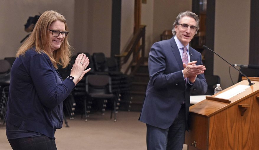North Dakota Gov. Doug Burgum leads a round of applause after recognizing sign language interpreter Lindsey Solberg Herbel during a recent COVID-19 briefing at the state Capitol in Bismarck, N.D. (Tom Stromme/The Bismarck Tribune via AP)