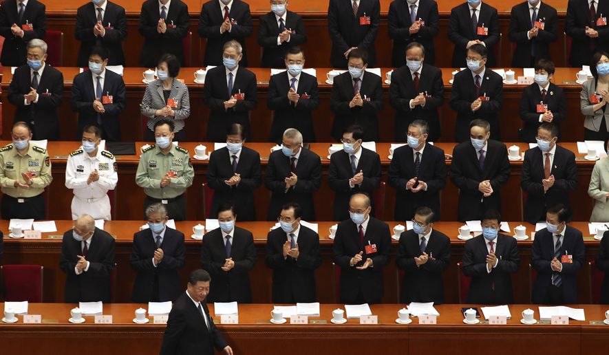 Delegates applaud as Chinese President Xi Jinping arrives for the opening session of China&#39;s National People&#39;s Congress (NPC) at the Great Hall of the People in Beijing, Friday, May 22, 2020. (AP Photo/Ng Han Guan, Pool)