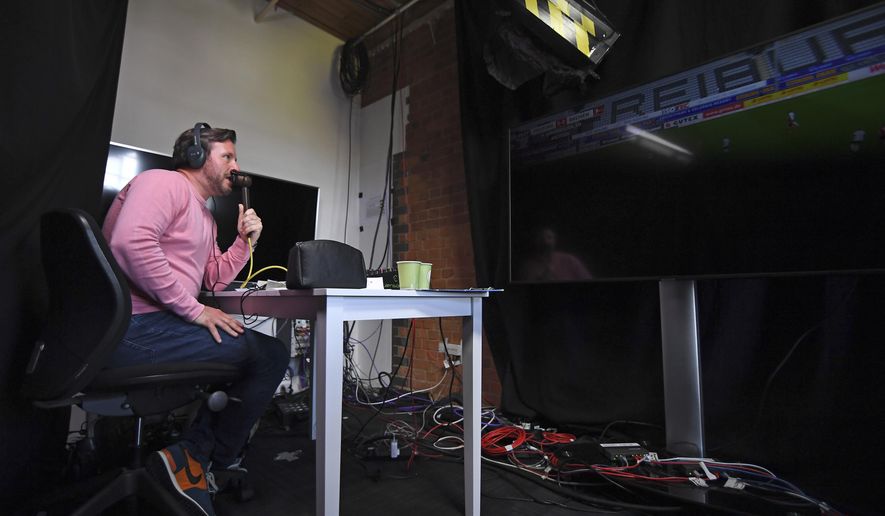 Soccer commentator Dan O'Hagan commentates on the German Bundesliga soccer match between Freiburg and Werder Bremen remotely from a studio in Camden Town, London, Saturday May 23, 2020. The Bundesliga is the only soccer major league to have resumed since the start of the coronavirus lockdown and with increased global demand matches are also being provided to customers with a commentary in English. (AP Photo/Alberto Pezzali)