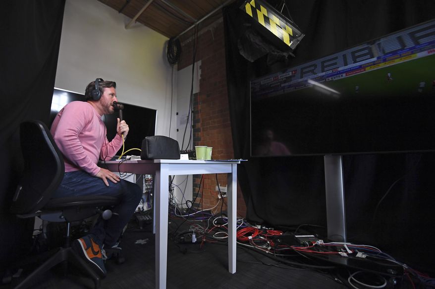 Soccer commentator Dan O'Hagan commentates on the German Bundesliga soccer match between Freiburg and Werder Bremen remotely from a studio in Camden Town, London, Saturday May 23, 2020. The Bundesliga is the only soccer major league to have resumed since the start of the coronavirus lockdown and with increased global demand matches are also being provided to customers with a commentary in English. (AP Photo/Alberto Pezzali)