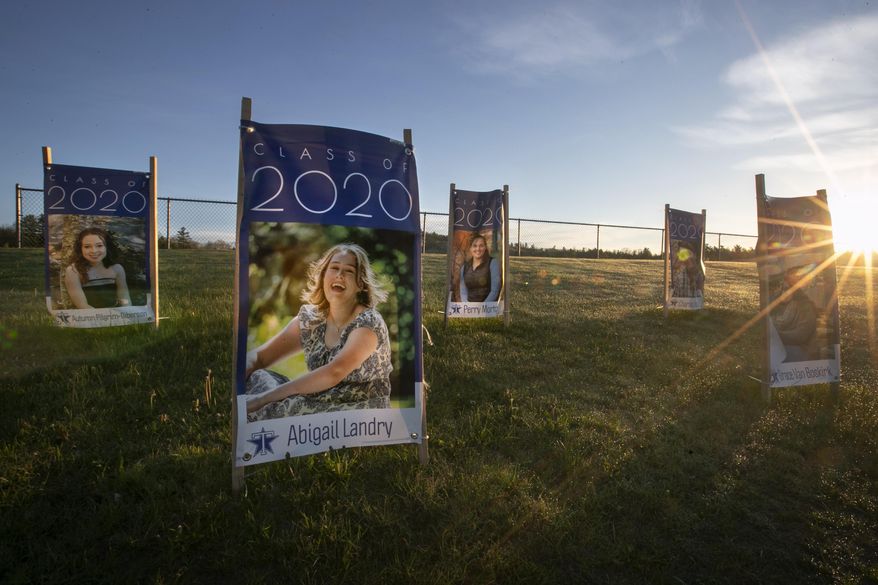 In this Friday, May 22, 2020 photo, portraits of graduating seniors at Telstar Regional High School are displayed near the school's athletic field in Bethel, Maine. Graduation week plans in early June include at town parade and commencement exercise at the Sunday River Ski Resort. (AP Photo/Robert F. Bukaty)