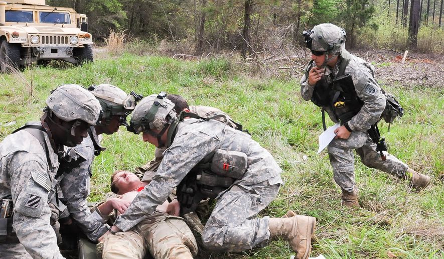 A health care specialist from C Company, 407th Brigade Support Battalion, 2nd Brigade Combat Team, 82nd Airborne Division, and a combat medical technician from the British 16 Air Assault Brigade, load a British Paratrooper with simulated injuries onto a litter during Combined Joint Operational Access Exercise 15-01 on Fort Bragg, N.C., April 18, 2015. Throughout CJOAX 15-01, medical teams from both forces trained on how to seamlessly integrate their respective life saving capabilities into a multinational force. CJOAX 15-01 is the largest bilateral exercise held on Fort Bragg in almost 20 years. (Photo by Sgt. Flor Gonzalez, 22nd Mobile Public Affairs Detachment)
