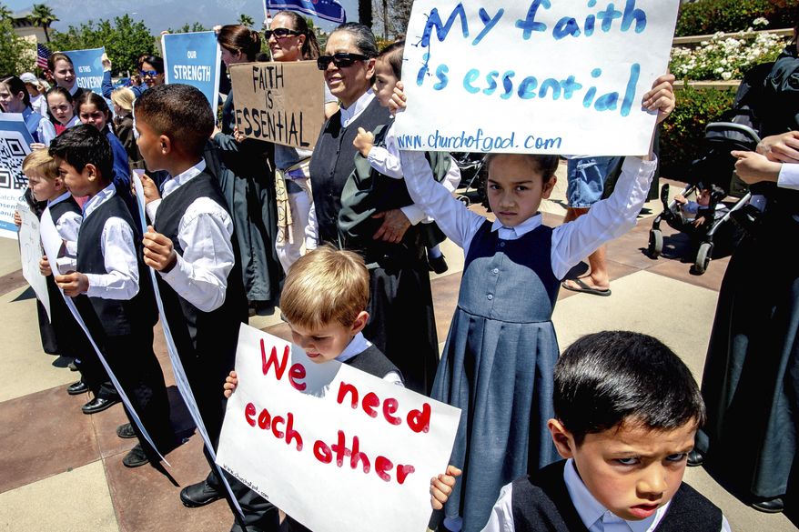 Young members of the Church of God hold signs during a demonstration against California's stay-at-home orders that were put in place due to the coronavirus outbreak, in Rancho Cucamonga, Calif. (Watchara Phomicinda/The Orange County Register via AP, File)