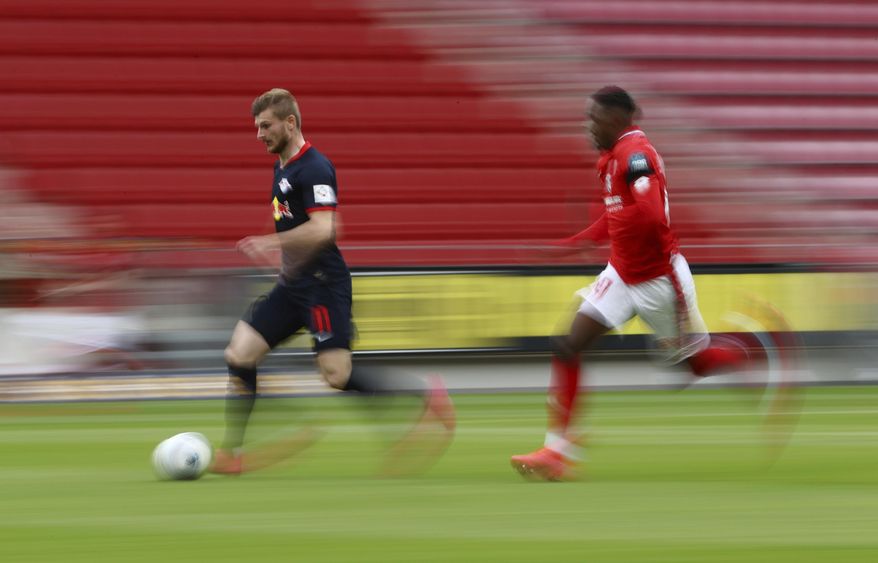 Leipzig's Timo Werner in action with 1.FSV Mainz 05's Moussa Niakhate during a German Bundesliga soccer match between FSV Mainz 05 and RB Leipzig in Mainz, Germany, Sunday, May 24, 2020. (Kai Pfaffenbach/pool via AP)