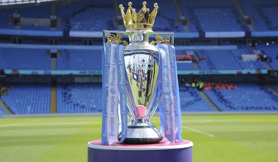 FILE - In this Sunday, May 6, 2018 file photo, the English Premier League trophy is displayed on the pitch prior to the English Premier League soccer match between Manchester City and Huddersfield Town at Etihad stadium in Manchester, England. A Bournemouth player is one of two positive tests for COVID-19 to emerge from the Premier League’s second round of testing, the club said on Sunday, May 24, 2020. The team said “medical confidentiality means the player’s name will not be disclosed” and added that he will self-isolate for seven days before being tested again at a later date. The league tested 996 players and club staff on Tuesday, Thursday, and Friday.  (AP Photo/Rui Vieira, File)