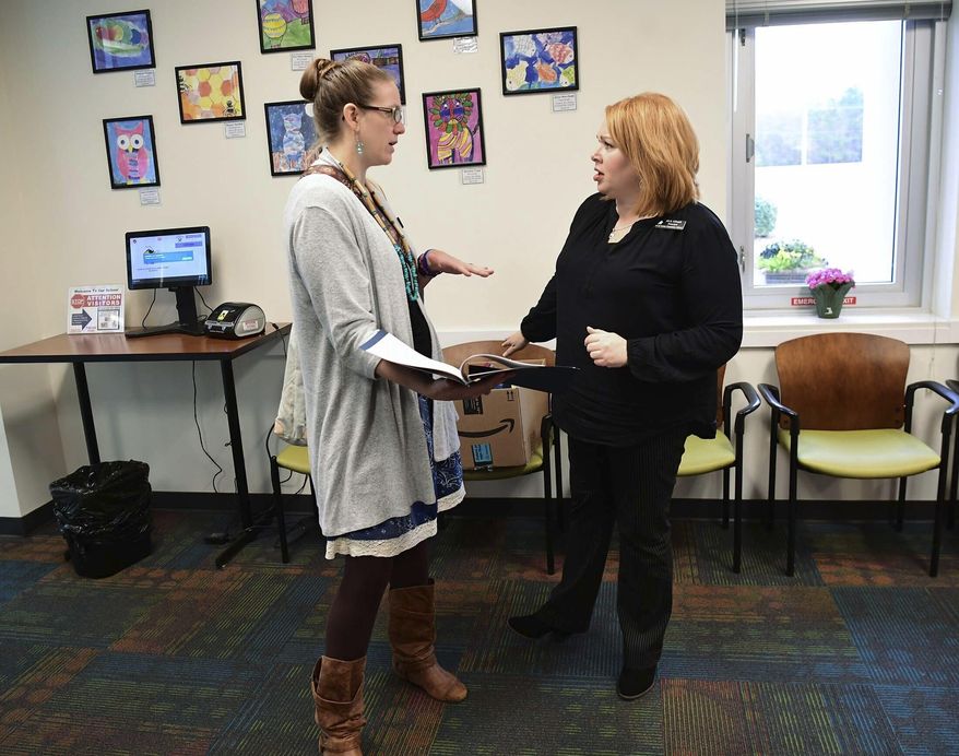 Erin Darnell, left, digital integration specialist for Anderson School District Five, talks about K3 and K4 study packets with North Pointe Elementary School Principal Jill Gilreath on Monday, March 16, 2020.(Ken Ruinard/The Independent-Mail via AP)