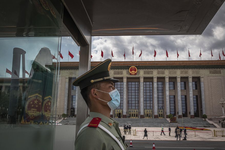 A Chinese People's Liberation Army (PLA) soldier wearing a protective face mask stands guard in front of the Great Hall of the People before the second plenary session of China's National People's Congress (NPC), in Beijing, Monday, May 25, 2020. (Roman Pilipey/Pool Photo via AP)