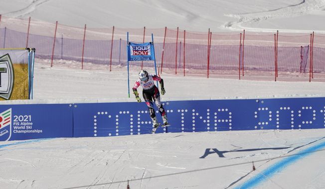 FILE - In this Jan. 20, 2019 file photo, Liechtenstein's Tina Weirather speeds down the course as a banner advertising the ski world championships in Cortina d’Ampezzo is seen in the background, during an alpine ski, women's World Cup super-G in Cortina D'Ampezzo, Italy. The Italian Winter Sports Federation (FISI) announced Sunday, May 24, 2020 that it would like to postpone next year’s Alpine skiing world championships in Cortina until March 2022 in order to avoid the championships being canceled or shortened due to the fallout in Italy from the coronavirus pandemic. (AP Photo/Giovanni Auletta, file)
