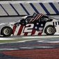 Brad Keselowski holds an American flag after winning the NASCAR Cup Series auto race at Charlotte Motor Speedway early Monday, May 25, 2020, in Concord, N.C. (AP Photo/Gerry Broome)
