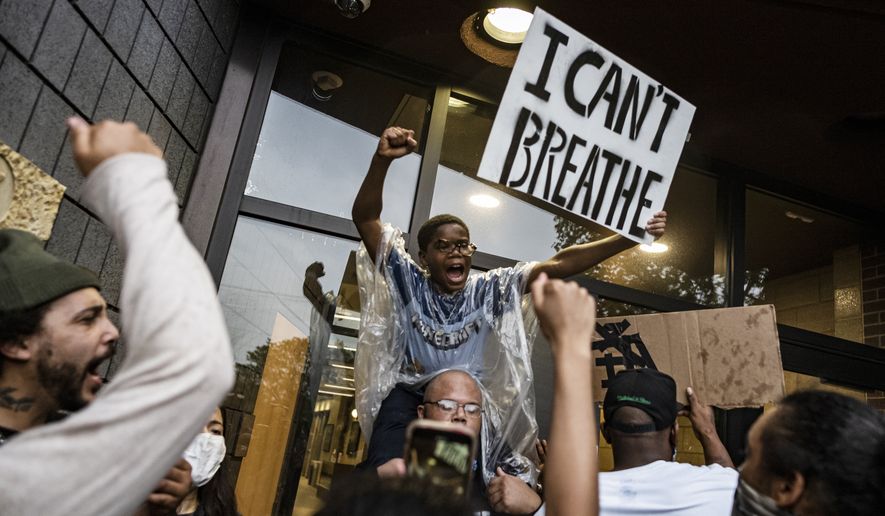 People gather at a police precinct during a protest for George Floyd in Minneapolis on Tuesday, May 26, 2020. Four Minneapolis officers involved in the arrest of the black man who died in police custody were fired Tuesday, hours after a bystander’s video showed an officer kneeling on the handcuffed man’s neck, even after he pleaded that he could not breathe and stopped moving. (Richard Tsong-Taatarii/Star Tribune via AP)