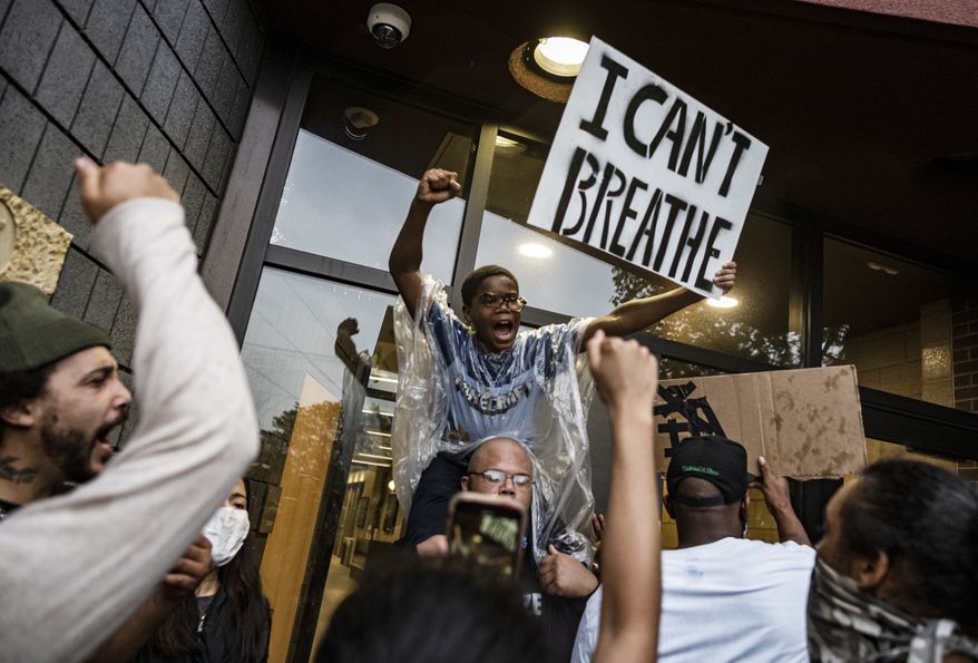 People gather at a police precinct during a protest for George Floyd in Minneapolis on Tuesday, May 26, 2020. Four Minneapolis officers involved in the arrest of the black man who died in police custody were fired Tuesday, hours after a bystander’s video showed an officer kneeling on the handcuffed man’s neck, even after he pleaded that he could not breathe and stopped moving. (Richard Tsong-Taatarii/Star Tribune via AP)
