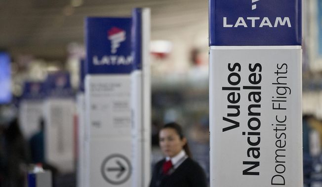 In this July 25, 2016, file photo, an agent of LATAM airlines stands by the counters at the airport in Santiago, Chile. The South American carrier said Tuesday, May 26, 2020, that it is seeking Chapter 11 bankruptcy protection as it grapples with the sharp downturn in air travel sparked by the coronavirus pandemic. (AP Photo/Esteban Felix, File)