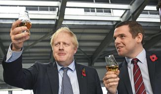 In this file photo dated Nov. 7, 2019, showing Britain&#x27;s Prime Minister Boris Johnson alongside Douglas Ross, parliamentary under-secretary of state for Scotland, right in Moray, Scotland. Junior British government minister Ross has quit Tuesday, May 26, 2020, over Johnson’s failure to fire his top aide Dominic Cummings for allegedly breaching COVID-19 coronavirus lockdown rules. (Stefan Rousseau/PA via AP)