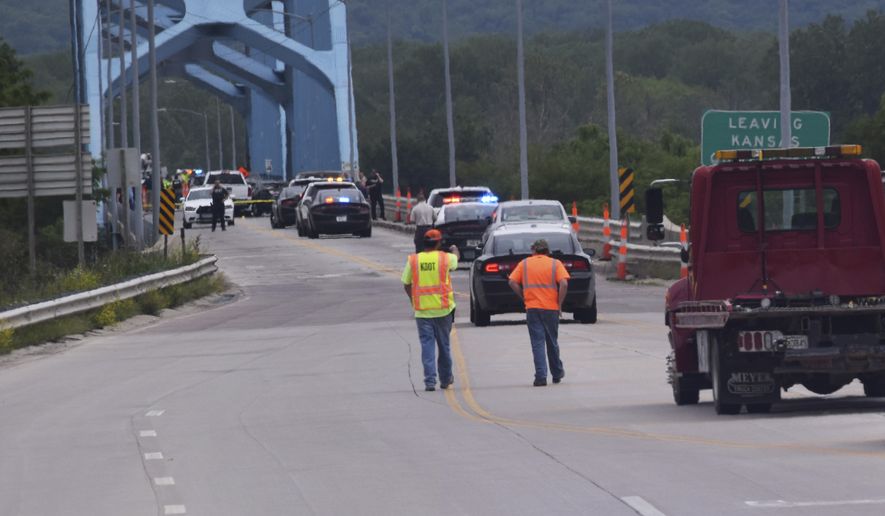 Authorities gather on Centennial Bridge after a shooting Wednesday, May 27, 2020, near Leavenworth, Kan. A Fort Leavenworth soldier is being credited with saving lives after he stopped a person who was randomly shooting on the bridge that connects Kansas and Missouri. (John Richmeier/Leavenworth Times via AP)