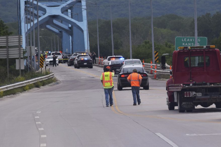 Authorities gather on Centennial Bridge after a shooting Wednesday, May 27, 2020, near Leavenworth, Kan. A Fort Leavenworth soldier is being credited with saving lives after he stopped a person who was randomly shooting on the bridge that connects Kansas and Missouri. (John Richmeier/Leavenworth Times via AP)