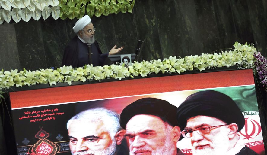 Iranian President Hassan Rouhani speaks during the inauguration of the new parliament, as a screen shows portraits of the Supreme Leader Ayatollah Ali Khamenei, right, late revolutionary founder Ayatollah Khomeini, center, and Gen. Qassem Soleimani, who was killed in Iraq in a U.S. drone attack in early January, in Tehran, Iran, Wednesday, May, 27, 2020.  (AP Photo/Vahid Salemi)