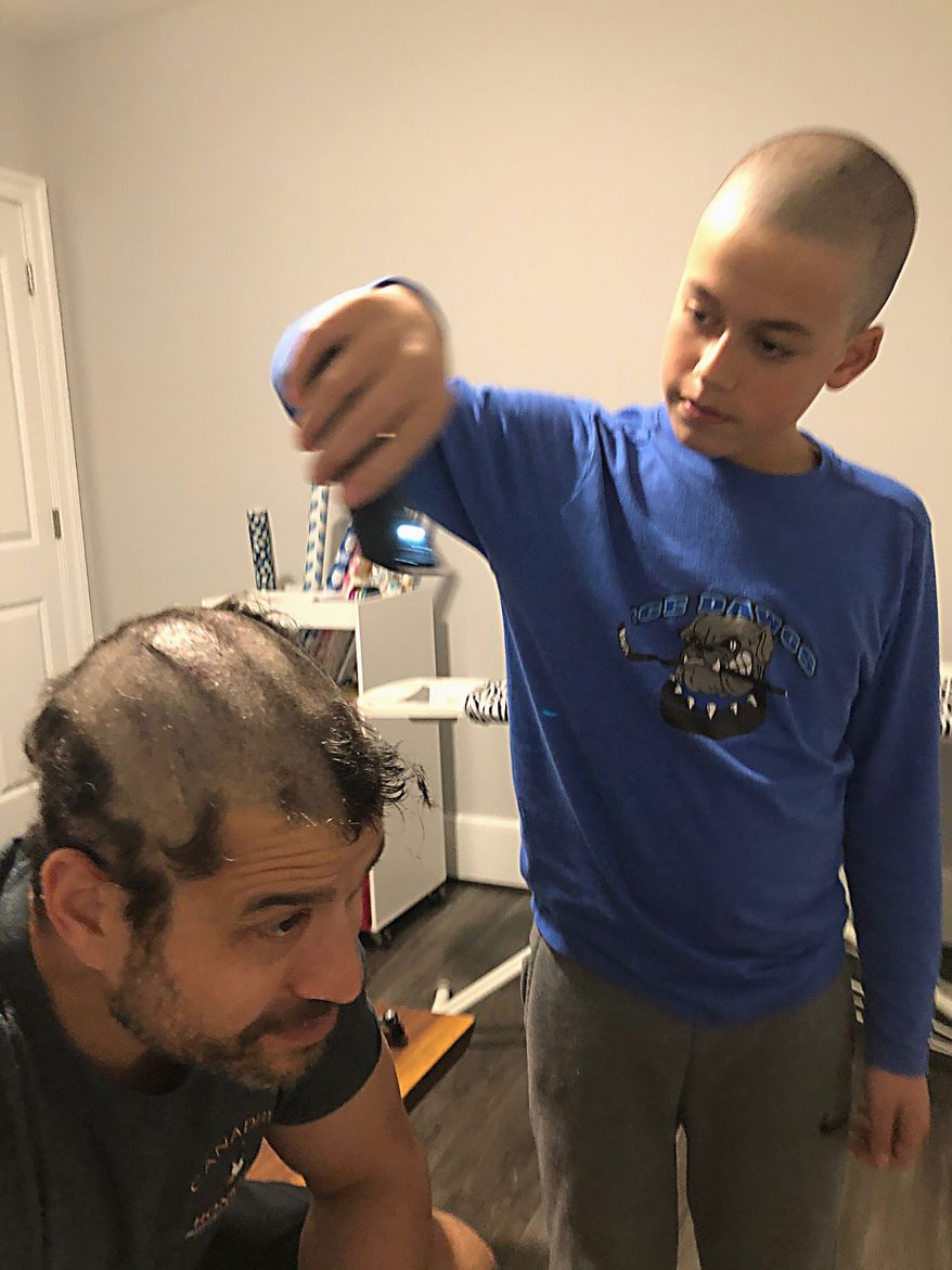 Evan Winston sits as his son, Tyler, cuts his hair as part of the Hercules Fence COVID-19 Charity Haircut Challenge. The fencing company has raised more than $13,000 for local food banks. (Courtesy of Evan Winston)