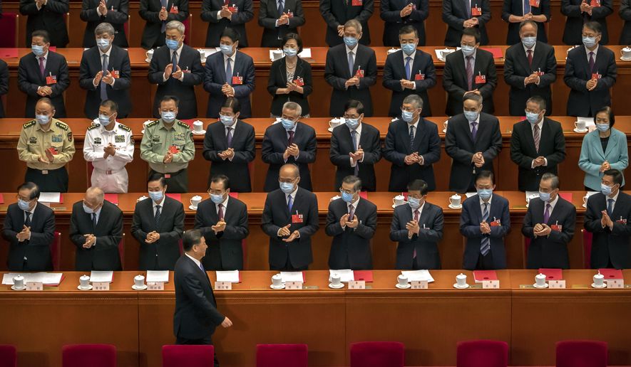 Delegates applaud as Chinese President Xi Jinping arrives for the closing session of China's National People's Congress (NPC) in Beijing, Thursday, May 28, 2020. China's ceremonial legislature has endorsed a national security law for Hong Kong that has strained relations with the United States and Britain. (AP Photo/Mark Schiefelbein)